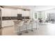 Open-concept kitchen with white cabinets, stainless steel appliances, and an island with seating for casual dining at 8986 Cabot Cliffs Dr, Davenport, FL 33896