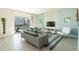 Bright, modern living room with tile flooring and a sliding glass door to the screened in patio and pool at 8986 Cabot Cliffs Dr, Davenport, FL 33896
