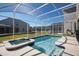 Relaxing screened-in pool and spa area offers clear blue water and sunny enjoyment at 8986 Cabot Cliffs Dr, Davenport, FL 33896