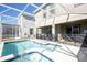 Enjoy the sparkling blue pool and spa in the screened-in lanai with backyard views at 8986 Cabot Cliffs Dr, Davenport, FL 33896