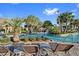 Resort-style pool with comfortable lounge seating, tiki umbrellas, tropical vegetation, and slide at 8986 Cabot Cliffs Dr, Davenport, FL 33896