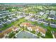 Expansive aerial view showcasing a community with lush landscaping, multiple homes, and the Oasis Club House at 9061 Dogleg Dr, Davenport, FL 33896