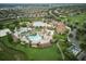 Expansive aerial view of the community pool and amenities, surrounded by lush greenery and landscaping at 9061 Dogleg Dr, Davenport, FL 33896