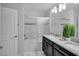Bright bathroom with a black vanity, granite counters, and tub with shower at 9061 Dogleg Dr, Davenport, FL 33896