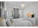 Bright bedroom offers a comfortable bed, and a dresser with a modern sphere style chandelier at 9061 Dogleg Dr, Davenport, FL 33896