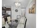 Bright dining room boasts a modern light fixture and a glass table with seating for six at 9061 Dogleg Dr, Davenport, FL 33896