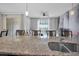 Open-concept kitchen featuring granite countertops, a breakfast bar, and views of the living area and pool at 9061 Dogleg Dr, Davenport, FL 33896
