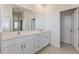 Modern bathroom featuring double sinks, white cabinets, large mirror, and tile floors at 9113 Wildlight, Wildwood, FL 34785