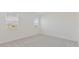 Bright bedroom featuring neutral carpet, two windows, and fresh paint at 9113 Wildlight, Wildwood, FL 34785