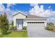Charming single-story home featuring a light blue front door, well-manicured lawn, and two-car garage at 9113 Wildlight, Wildwood, FL 34785