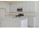 Bright kitchen featuring white cabinets, stainless steel appliances, quartz countertops and center island at 9113 Wildlight, Wildwood, FL 34785
