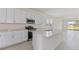 Modern kitchen featuring white cabinets, stainless steel appliances, large island, and tile flooring at 9113 Wildlight, Wildwood, FL 34785