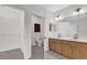 Bathroom featuring double sinks, wood cabinetry, a toilet room, and access to a closet at 9435 Myrtle Creek Ln # 308, Orlando, FL 32832