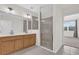 Bright bathroom featuring dual sinks, wood cabinets, a glass shower and neutral tiling at 9435 Myrtle Creek Ln # 308, Orlando, FL 32832