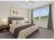 Neutral bedroom showcasing a large window and decorative wall art for a peaceful retreat at 9435 Myrtle Creek Ln # 308, Orlando, FL 32832