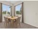 A well-lit dining room featuring two large windows overlooking a lush landscape and a table with four chairs at 9435 Myrtle Creek Ln # 308, Orlando, FL 32832