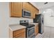 Well-lit kitchen features stainless steel appliances, wooden cabinetry and light countertops at 9435 Myrtle Creek Ln # 308, Orlando, FL 32832