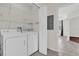 Well-equipped laundry area with washer, dryer, wire shelves, and easy access to other rooms at 9435 Myrtle Creek Ln # 308, Orlando, FL 32832