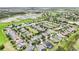A sprawling community viewed from above, bordered by natural wetlands and lush green fields at 106 Mist Flower Ln, Groveland, FL 34736