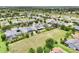 An elevated view showcases a residential area with homes featuring screened pools and solar panels amidst green lawns at 106 Mist Flower Ln, Groveland, FL 34736