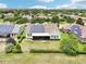Beautiful aerial view of a home with solar panels, a well-maintained backyard, and a screened-in lanai at 106 Mist Flower Ln, Groveland, FL 34736