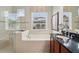 Bathroom featuring a large soaking tub, vanity, dual sinks, and a separate walk-in shower at 106 Mist Flower Ln, Groveland, FL 34736