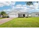 Charming single-story home with a well-manicured lawn, inviting entrance, and brick paved driveway at 106 Mist Flower Ln, Groveland, FL 34736