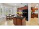 Well-lit kitchen features cherry wood cabinets, black appliances, granite counters, and a cozy breakfast nook with large window at 106 Mist Flower Ln, Groveland, FL 34736