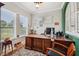 Home office with wooden desk, plush rug, and bright windows at 106 Mist Flower Ln, Groveland, FL 34736