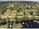 Wide aerial shot of a lakeside residential area, featuring boat docks and lush landscaping at 12130 Lakeshore Dr, Clermont, FL 34711