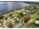 Aerial view showcases a sprawling lakeside property featuring mature trees and a tennis court at 12130 Lakeshore Dr, Clermont, FL 34711