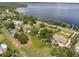 Stunning aerial view of waterfront property with private pool, tennis court, and lake access at 12130 Lakeshore Dr, Clermont, FL 34711