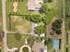 Aerial view highlighting property layout with a large yard, driveway, and nearby tennis court at 12130 Lakeshore Dr, Clermont, FL 34711