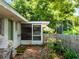 Backyard exterior showcasing screened-in porch and landscaped greenery and fence at 12130 Lakeshore Dr, Clermont, FL 34711