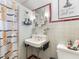 Cozy bathroom with patterned shower curtain, white tiles, and a framed inspirational quote at 12130 Lakeshore Dr, Clermont, FL 34711