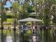 Picturesque boat dock on the water, surrounded by cypress trees draped with Spanish moss at 12130 Lakeshore Dr, Clermont, FL 34711