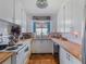 Bright kitchen featuring white cabinetry, butcher block countertops, and classic tile flooring at 12130 Lakeshore Dr, Clermont, FL 34711