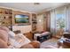 Cozy living room featuring built-in shelves, a plush sofa, and ample natural light at 12130 Lakeshore Dr, Clermont, FL 34711