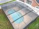 Aerial view showcases the pool with brick surround and the screened enclosure in a lush yard at 12300 Abberton Ct, Orlando, FL 32837