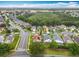 An aerial view of a suburban neighborhood with mature trees and a home featuring an enclosed swimming pool at 12300 Abberton Ct, Orlando, FL 32837