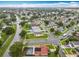 An aerial view of the neighborhood with lush green landscaping and a home featuring a beautiful enclosed pool at 12300 Abberton Ct, Orlando, FL 32837