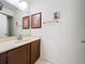 Bathroom featuring a single sink vanity and a wall mirror with decorative pictures hanging above at 12300 Abberton Ct, Orlando, FL 32837