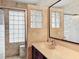 Bathroom features a shower with glass block window and a vanity with tile backsplash at 12300 Abberton Ct, Orlando, FL 32837