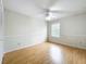 A clean, empty bedroom featuring neutral walls, wooden floors, ceiling fan, and a window allowing natural light at 12300 Abberton Ct, Orlando, FL 32837