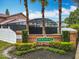The Plantation entrance sign with a glimpse of the home's enclosed pool and screened-in patio at 12300 Abberton Ct, Orlando, FL 32837