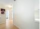 Hallway view with neutral paint, wood-look floors, and bathroom access at 12300 Abberton Ct, Orlando, FL 32837