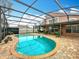 Beautiful in-ground screened pool surrounded by brick pavers, complemented by a comfortable swing and manicured foliage at 12300 Abberton Ct, Orlando, FL 32837