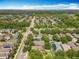 Expansive aerial view of a neighborhood with tree-lined streets, well-maintained homes, and lush landscaping on a sunny day at 13055 Overstreet Rd, Windermere, FL 34786