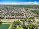 Expansive aerial view of homes surrounding a beautiful lake and natural wooded areas at 13055 Overstreet Rd, Windermere, FL 34786