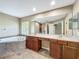Bright bathroom with dual vanities, soaking tub with tile surround, and ample counter space at 13055 Overstreet Rd, Windermere, FL 34786
